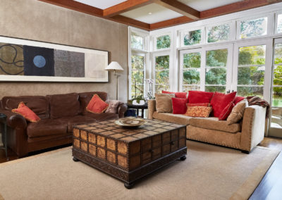 renovations - windows - couches - pillows - art - tudor ceiling - area rug - living area