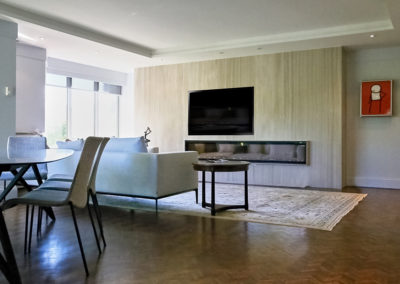 livingroom -fireplace - fire insert - area rug - granite wall - flatscreen - sectional - television -tv -